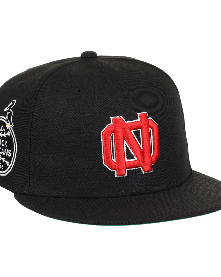 The EFF New Orleans Black Pelicans NLB Team Color Fitted Ballcap in black features a large red and white ND logo on the front and a round side patch with a pelican, inspired by classic Negro Southern League style.