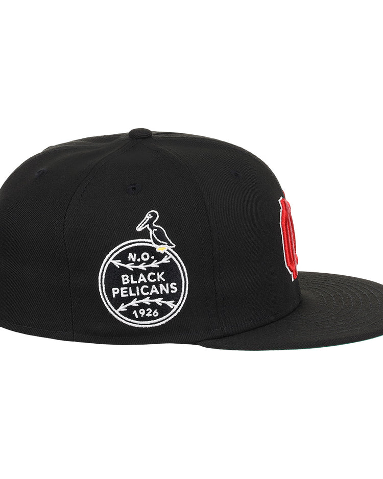 The EFF New Orleans Black Pelicans NLB Team Color Fitted Ballcap in black features a vintage-style circular pelican patch with “N.O. Black Pelicans 1926” and a red embroidered letter visible from the front side, honoring the historic team.