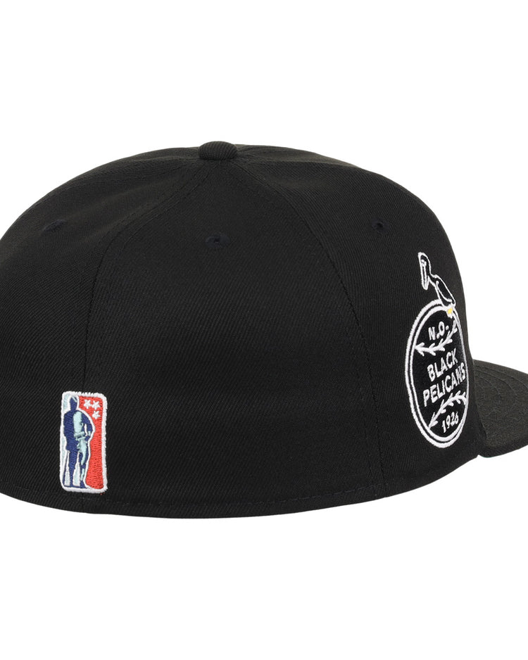 The EFF New Orleans Black Pelicans NLB Team Color Fitted Ballcap in black features a round team patch on the side, a small red, white, and blue baseball player logo near the back, and a flat brim.