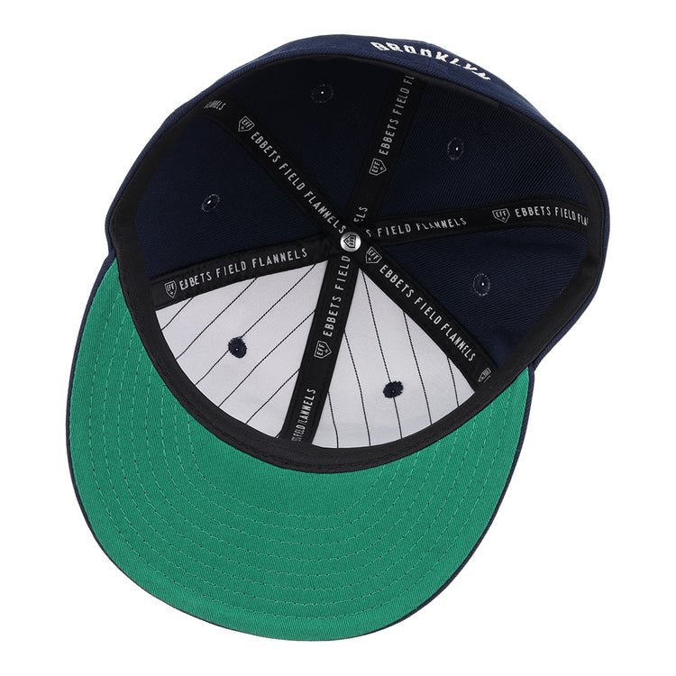 A navy Brooklyn Eagles NLB Team Color Fitted Ballcap by EFF, seen from below with a green underbrim, black and white pinstriped lining, and EBBETS FIELD FLANNELS printed on the inner seams.