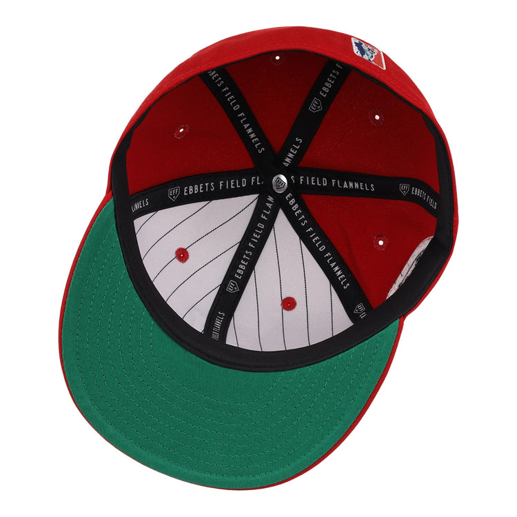 The image shows the inside of an EFF Jax Red Caps NLB Team Color Fitted Ballcap, featuring a green underbrim, black inner band with EBBETS FIELD FLANNELS in white, and white pinstripes lining the interior.