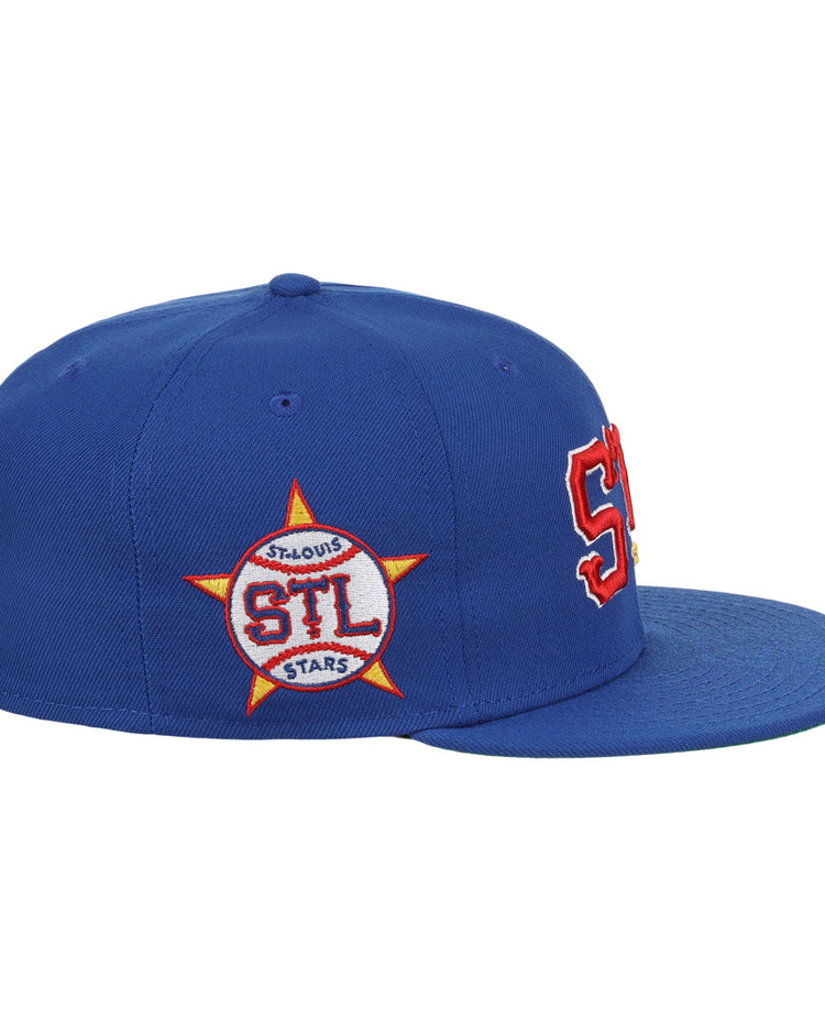 The EFF St. Louis Stars NLB Team Color Fitted Ballcap features a royal blue vintage style, bold red and white STL letters on the front, and a side star patch with STL ST. LOUIS STARS in red and white.