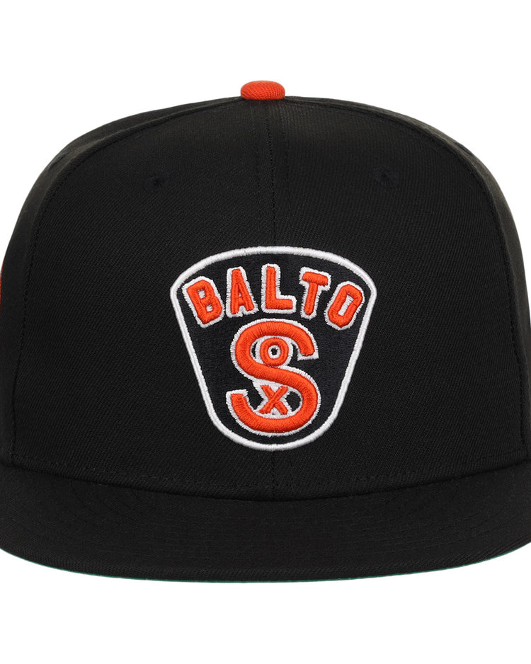 The EFF Baltimore Black Sox NLB Team Color Fitted Ballcap is a vintage-inspired black cap with a flat brim and a front patch reading BALTO above an orange and white S, honoring the Eastern Colored League.