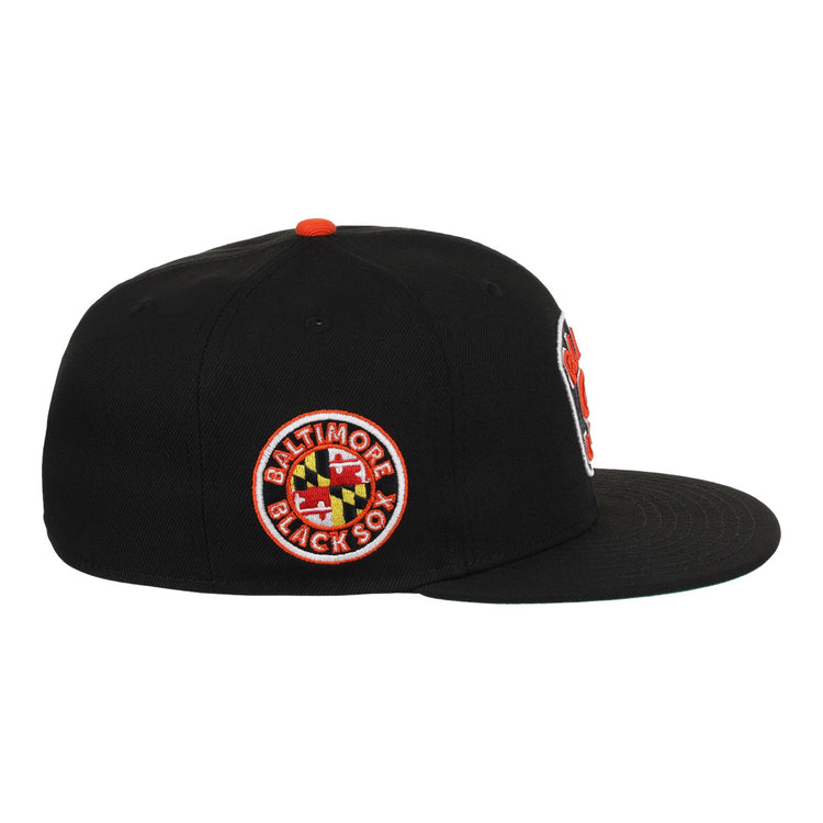The EFF Baltimore Black Sox NLB Team Color Fitted Ballcap is a vintage-inspired black cap with a flat brim and a side patch featuring the team name and Maryland flag, honoring their Eastern Colored League legacy.