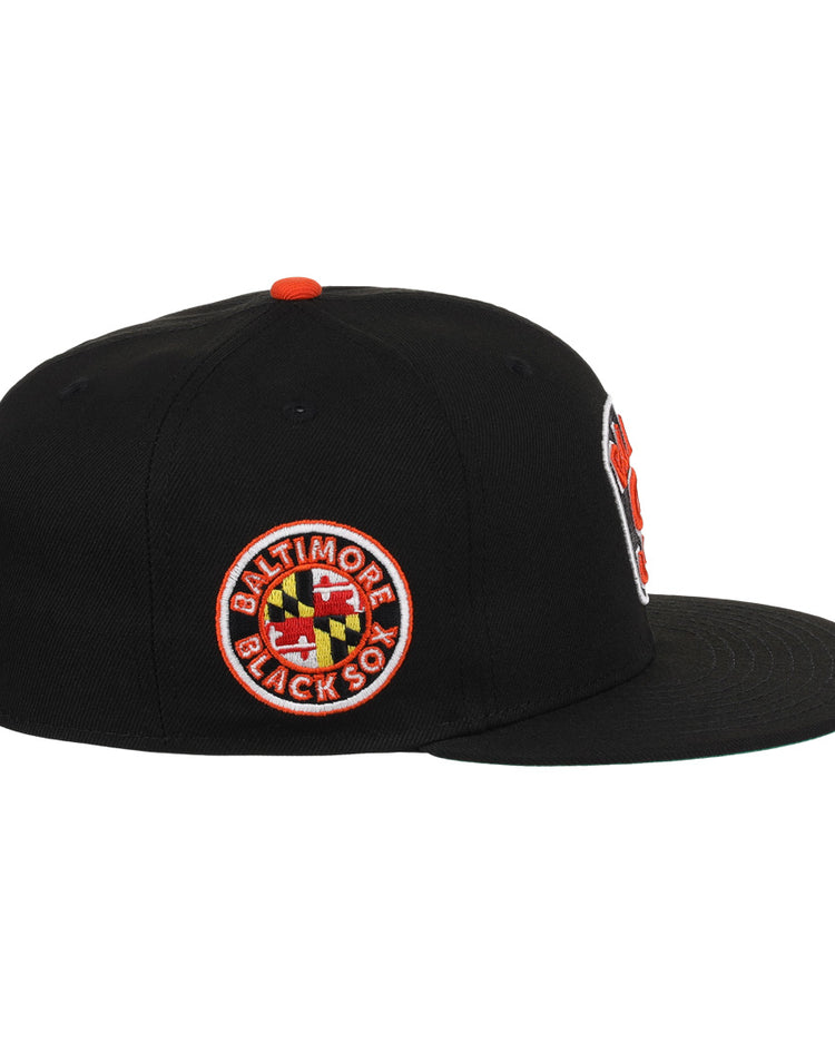 The EFF Baltimore Black Sox NLB Team Color Fitted Ballcap is a vintage-inspired black cap with a flat brim and a side patch featuring the team name and Maryland flag, honoring their Eastern Colored League legacy.