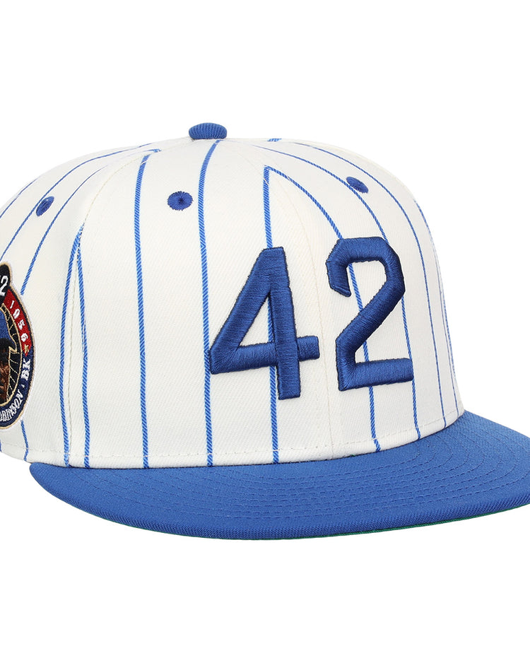 The EFF Jackie Robinson EFF Signature Series Fitted Ballcap - Pinstripe features blue pinstripes, a blue brim, 3D embroidered 42 on the front, and a circular patch with red, white, and blue accents on the side.