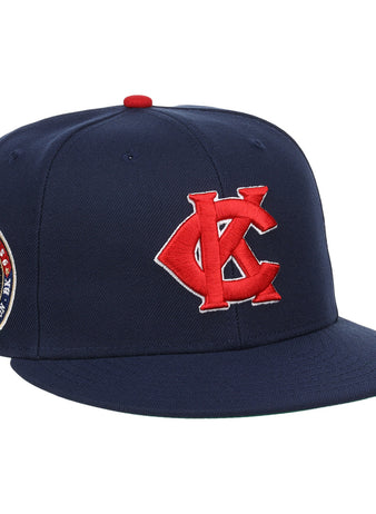 The EFF Kansas City Monarchs Robinson Fitted Ballcap in navy features a red embroidered KC logo, a Jackie Robinson #42 patch on the side, and a bold red button on top.