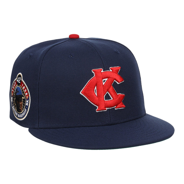 The EFF Kansas City Monarchs Robinson Fitted Ballcap in navy features a red embroidered KC logo, a Jackie Robinson #42 patch on the side, and a bold red button on top.