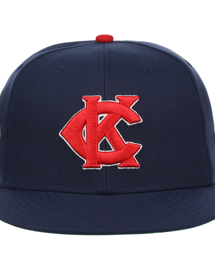 The EFF Kansas City Monarchs Robinson Fitted Ballcap in navy features a red and white embroidered KC logo on the front, inspired by Jackie Robinson’s iconic cap, and is finished with a red top button.