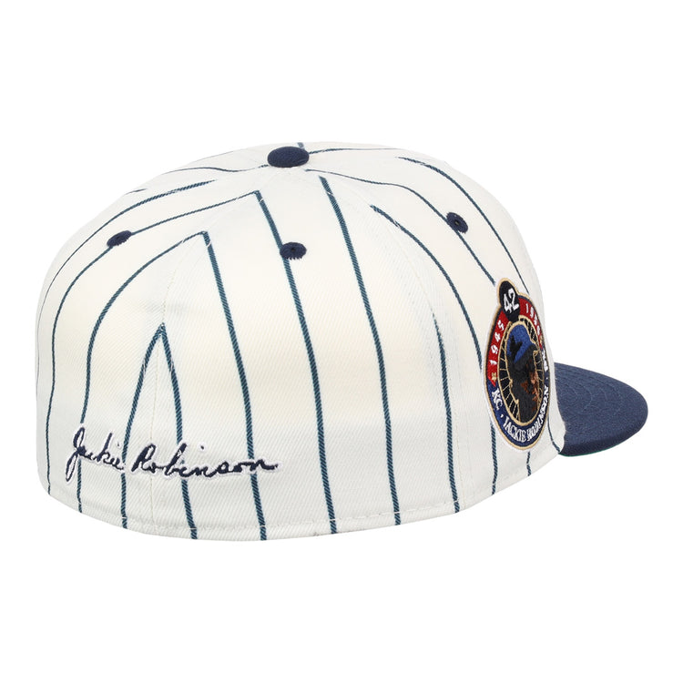 The Kansas City Monarchs EFF Monarchs Robinson Fitted Ballcap - Pinstripe by EFF features a white pinstriped design, blue brim, embroidered KC logo, Jackie Robinsons signature on the side, and a commemorative patch on the front side panel.