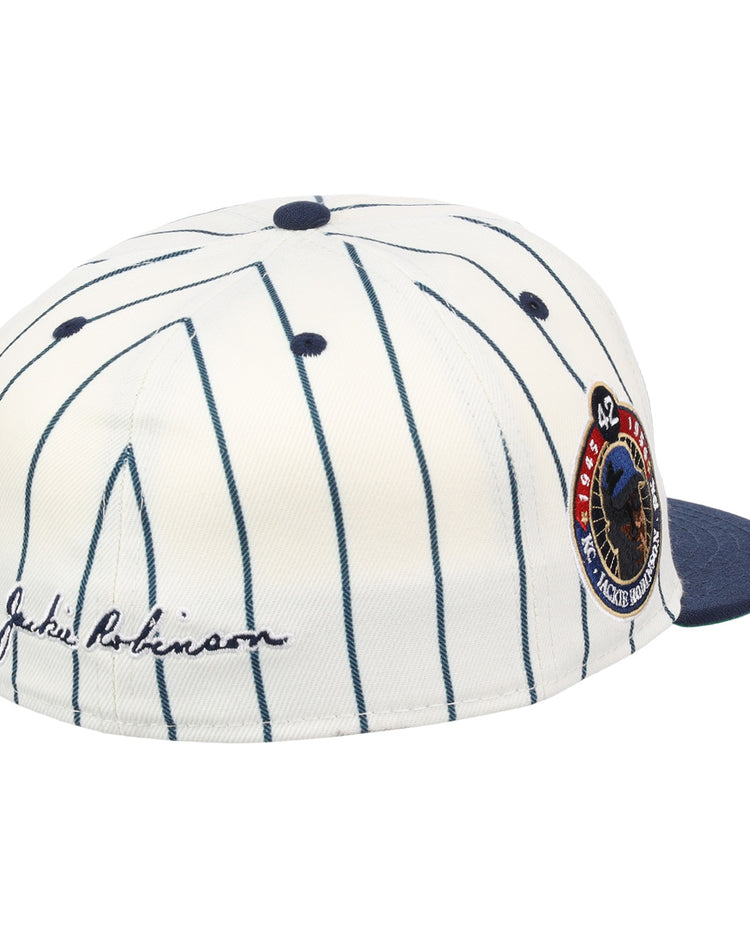 The Kansas City Monarchs EFF Monarchs Robinson Fitted Ballcap - Pinstripe by EFF features a white pinstriped design, blue brim, embroidered KC logo, Jackie Robinsons signature on the side, and a commemorative patch on the front side panel.