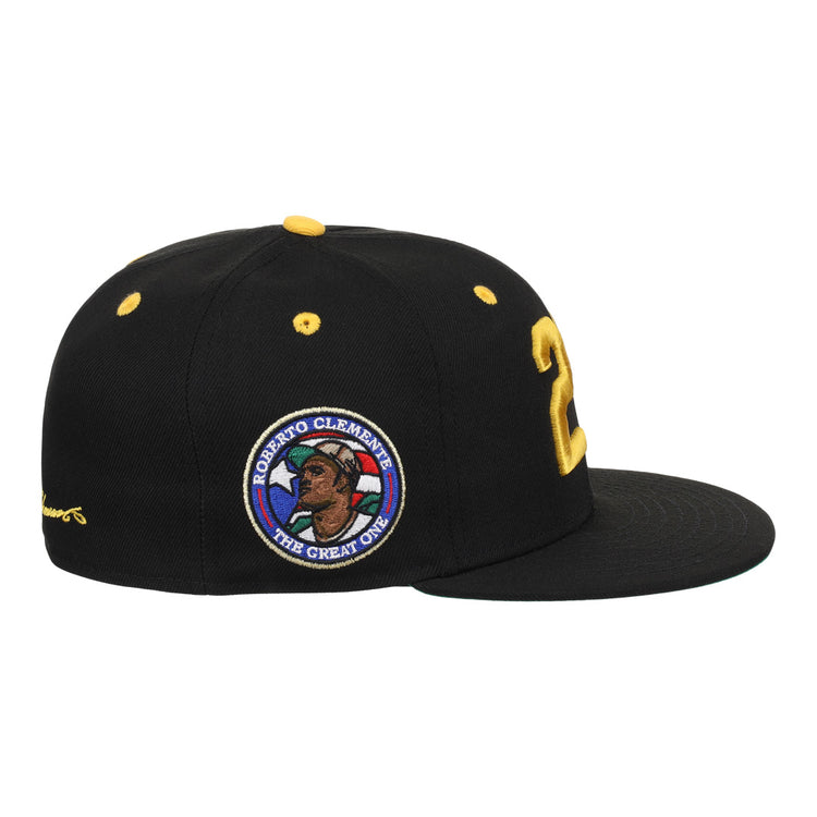 The EFF Roberto Clemente Signature Series Fitted Ballcap in black features yellow accents, a bold yellow 21 on the side, and a circular patch with Clemente’s portrait and “The Great One.”.