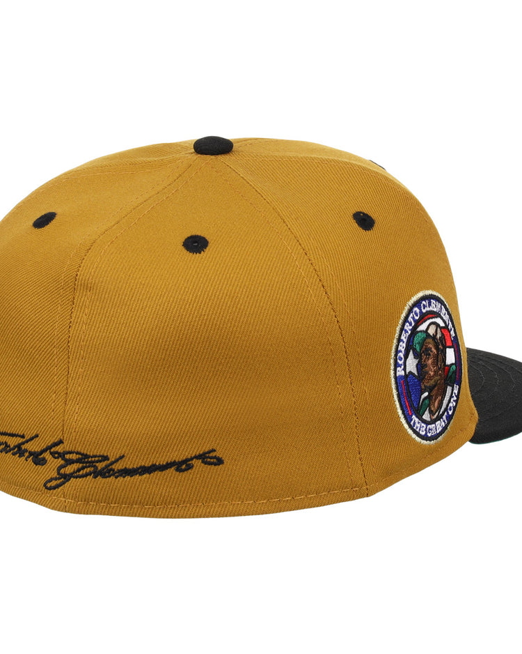 The EFF Roberto Clemente EFF Signature Series Fitted Ballcap in gold features a black brim, black top button, black ventilation eyelets, a round embroidered side patch, and cursive script on the back left panel.