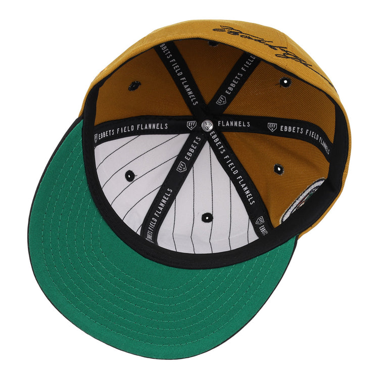 The EFF Roberto Clemente Signature Series Fitted Ballcap in gold features a green underbill, black and white pinstriped inner lining, black trim with EBBETS FIELD FLANNELS text, and classic 3D embroidered details.