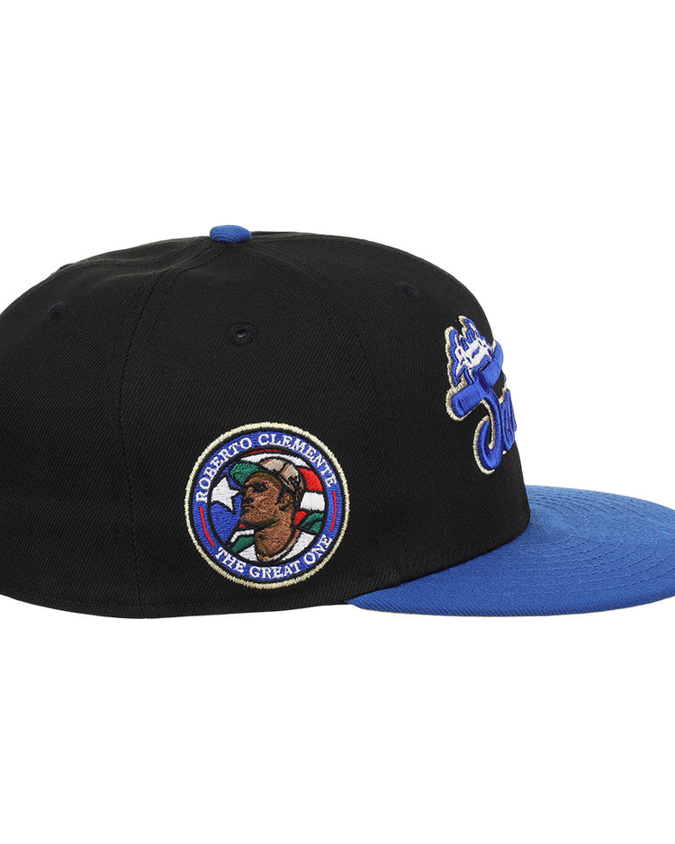 The EFF Santurce Cangrejeros Clemente Fitted Ballcap in black features a blue visor, side patch of Roberto Clemente with ROBERTO CLEMENTE THE GREAT ONE, and embroidered front and back designs.
