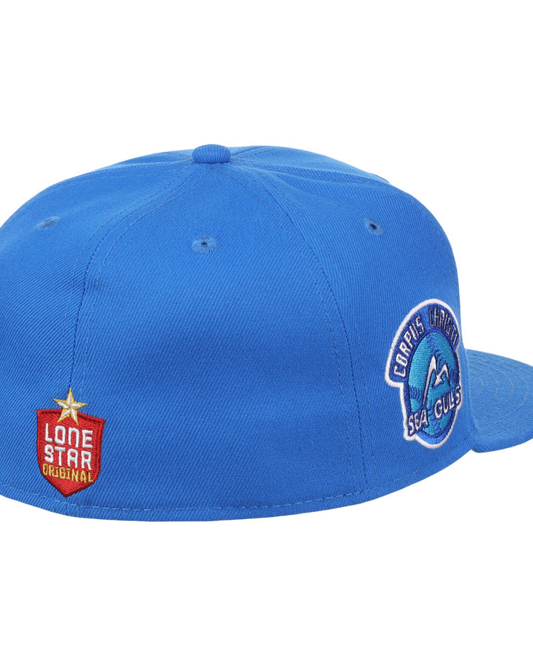 The Corpus Christi Seagulls EFF Lone Star Fitted Ballcap by EFF is blue with a round Seagulls patch on the side and a red Lone Star League Original patch featuring a gold star on the back left.