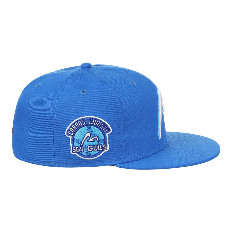 The EFF Corpus Christi Seagulls Lone Star Fitted Ballcap is a blue cap with a flat brim and side patch featuring “Corpus Christi Sea Gulls” with a wave and seagull, honoring the iconic Lone Star League team.