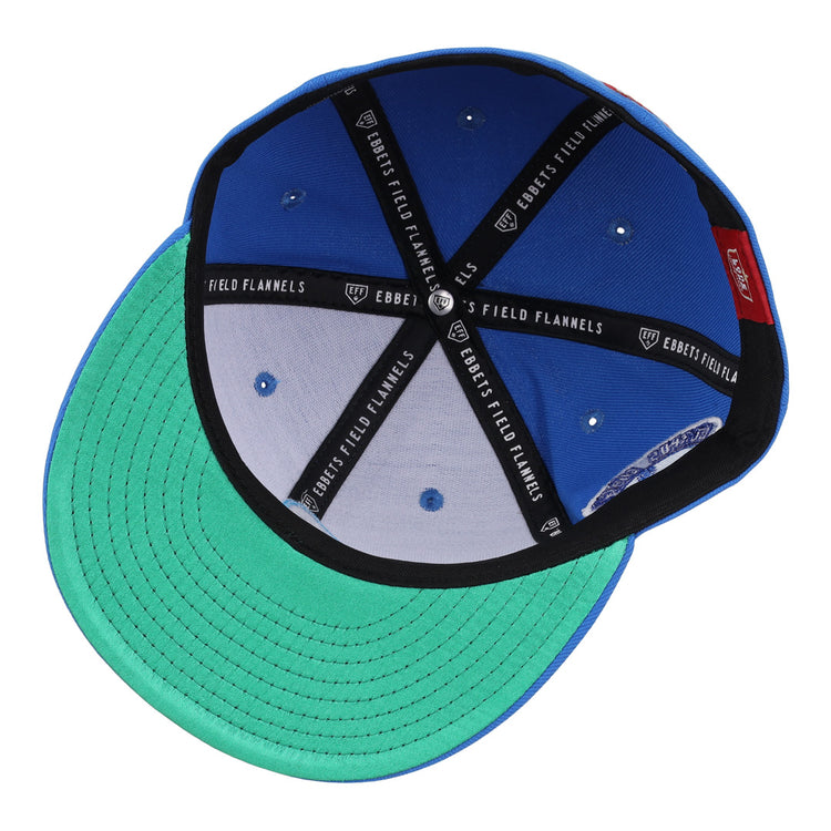 The EFF Corpus Christi Seagulls Lone Star Fitted Ballcap features a blue and green design, black interior seams labeled EFF, silver eyelets, a green underbrim, and a red inner tag—a tribute to the historic Lone Star League team.