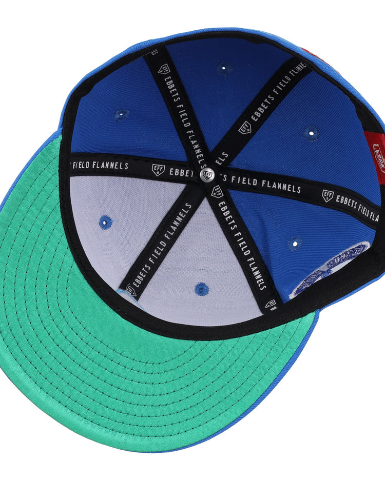 The EFF Corpus Christi Seagulls Lone Star Fitted Ballcap features a blue and green design, black interior seams labeled EFF, silver eyelets, a green underbrim, and a red inner tag—a tribute to the historic Lone Star League team.