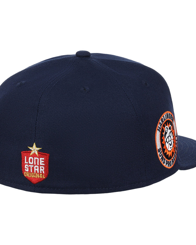 The Harlingen Suns EFF Lone Star Fitted Ballcap by EFF is navy blue with a round orange and white side patch, a Lone Star Original red badge on the back, and a button on top. The front of this cap isn’t shown.