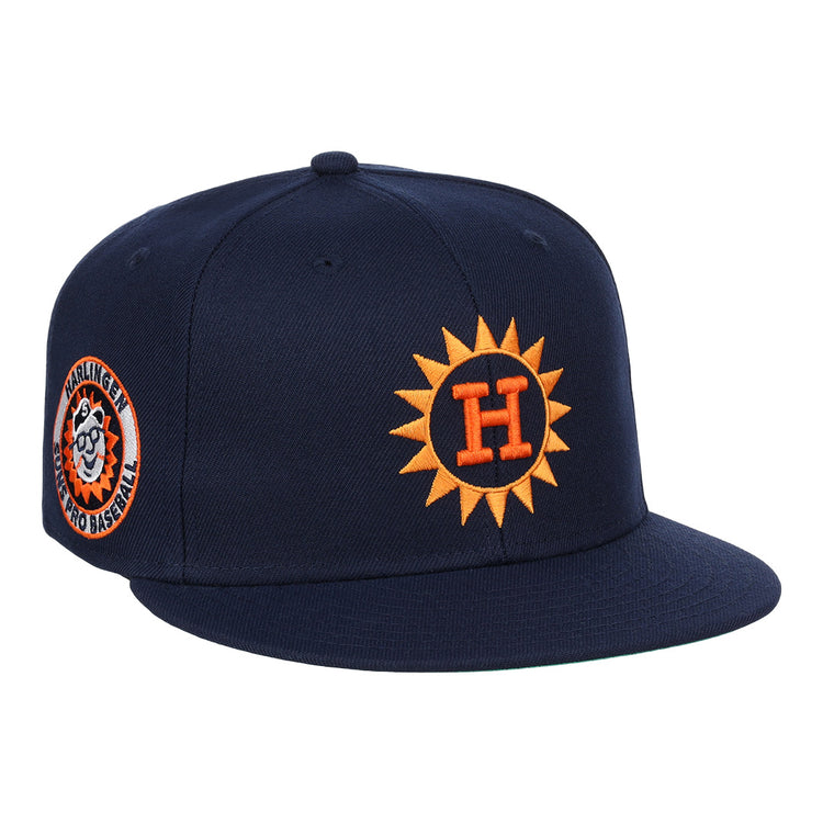 The Harlingen Suns EFF Lone Star Fitted Ballcap by EFF features a navy blue design with a 3D orange sun logo with a white H on the front, and a side patch of a smiling baseball and Harlingen Sunbirds Pro Baseball in the Lone Star League.