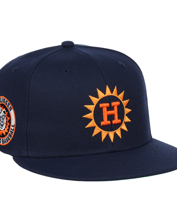 The Harlingen Suns EFF Lone Star Fitted Ballcap by EFF features a navy blue design with a 3D orange sun logo with a white H on the front, and a side patch of a smiling baseball and Harlingen Sunbirds Pro Baseball in the Lone Star League.