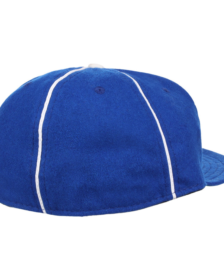 The Almendares Alacranes 1931 Vintage Ballcap by Ebbets Field Flannels is a blue wool hat with white piping, seen from the back and side, featuring a rounded crown and curved brim.