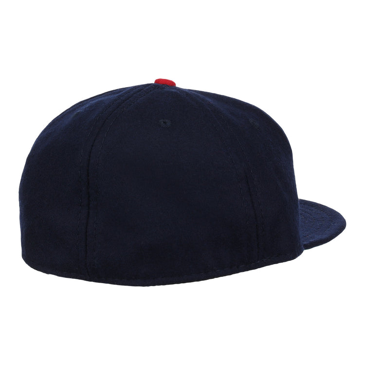 The Carta Blanca 1939 Vintage Ballcap by Ebbets Field Flannels is a navy blue cap with a red top button and panel stitching, inspired by classic Mexican League style and viewed from the back.