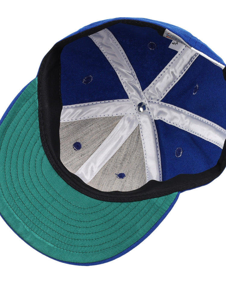 A close-up of the interior of the EFF Seattle Royal Giants 1935 Vintage Ballcap reveals green brim, interior stitching, sweatband, and silver support strips on this authentic wool cap.