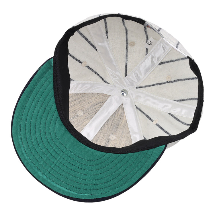 The image displays the inside of an Ebbets Field Flannels Vedado TC 1930 Vintage Ballcap, featuring a green brim, white interior panels, black seams, and a metallic top button from the Cuban National Amateur League.
