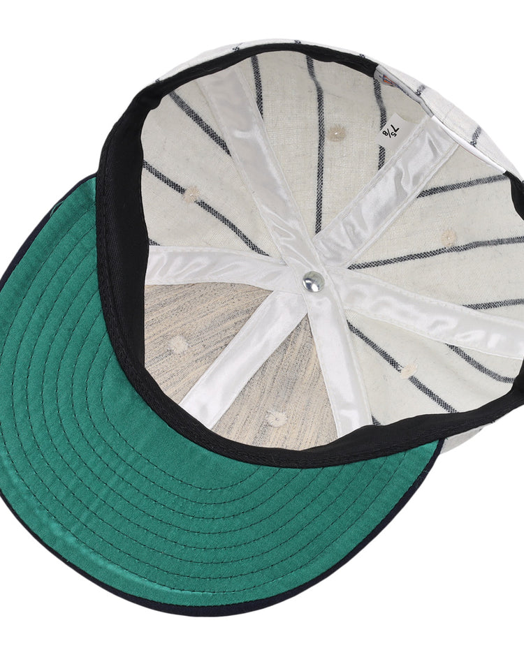 The image displays the inside of an Ebbets Field Flannels Vedado TC 1930 Vintage Ballcap, featuring a green brim, white interior panels, black seams, and a metallic top button from the Cuban National Amateur League.