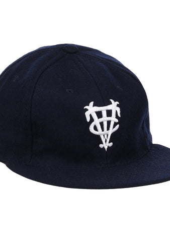 The Vedado TC 1945 Vintage Ballcap by Ebbets Field Flannels is a navy cap with a white interlocking letter logo, inspired by the Cuban National Amateur League, and features a curved brim and structured crown.