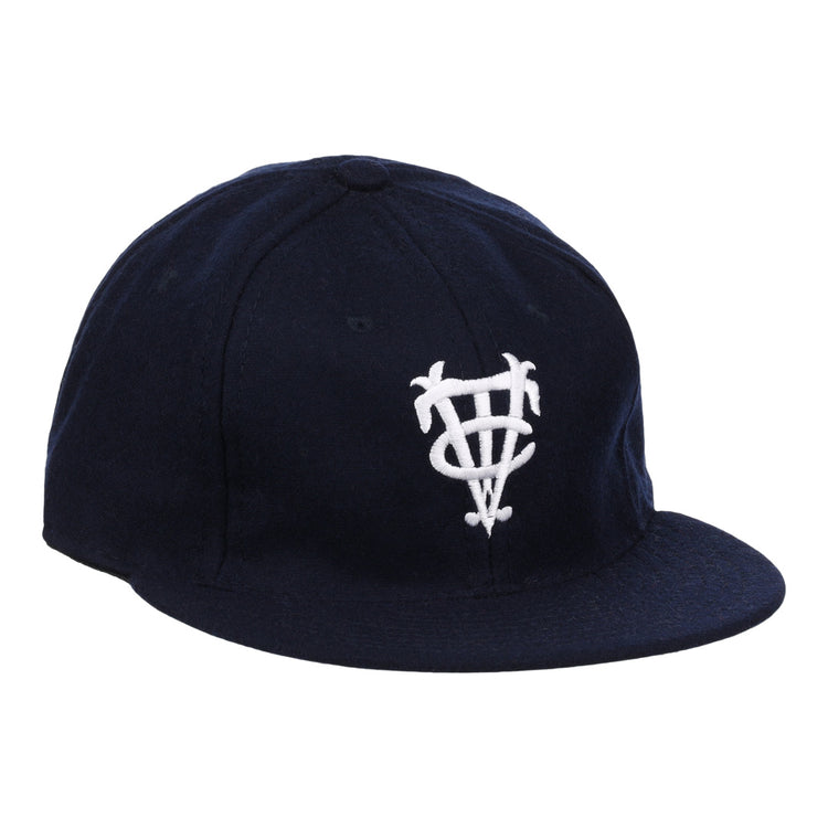 The Vedado TC 1945 Vintage Ballcap by Ebbets Field Flannels is a navy cap with a white interlocking letter logo, inspired by the Cuban National Amateur League, and features a curved brim and structured crown.