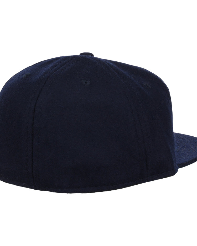 A plain, dark navy Vedado TC 1945 Vintage Ballcap by Ebbets Field Flannels, shown from the back and slightly to the side with no visible logos or designs, evokes a classic look from the Cuban National Amateur League.