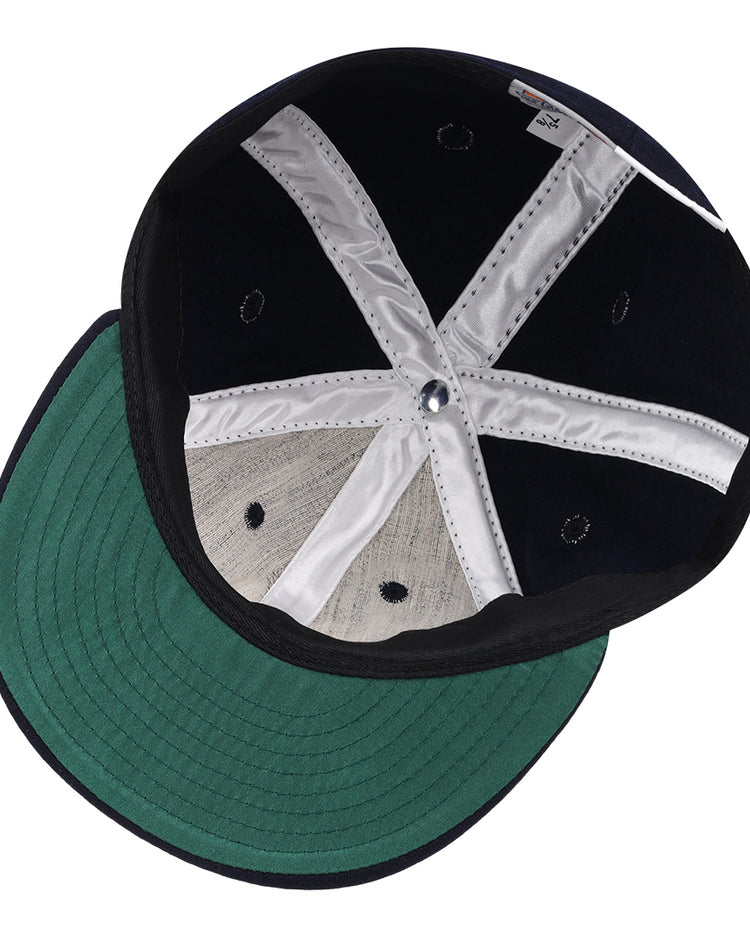 The image shows the inside of an Ebbets Field Flannels Vedado TC 1945 Vintage Ballcap with a green underside on the brim, white interior support bands, and dark navy panels—reminiscent of classic Cuban National Amateur League style.