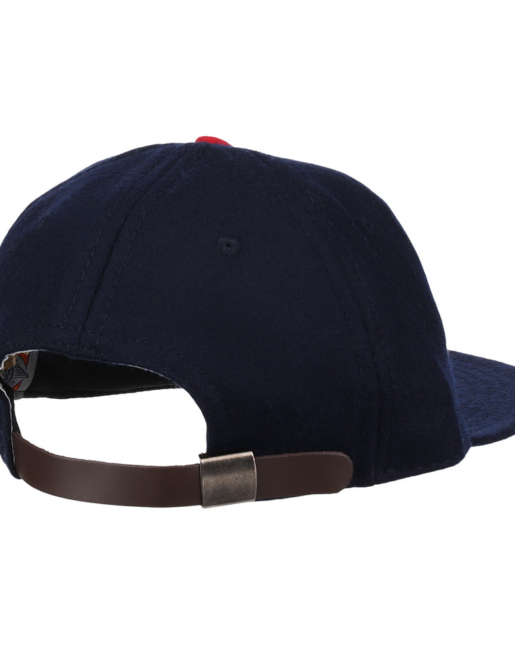The Carta Blanca 1939 Vintage Ballcap by Ebbets Field Flannels is a navy blue cap, pictured from the back, with a brown adjustable strap and metal clasp, inspired by the 1939 Mexican League original.