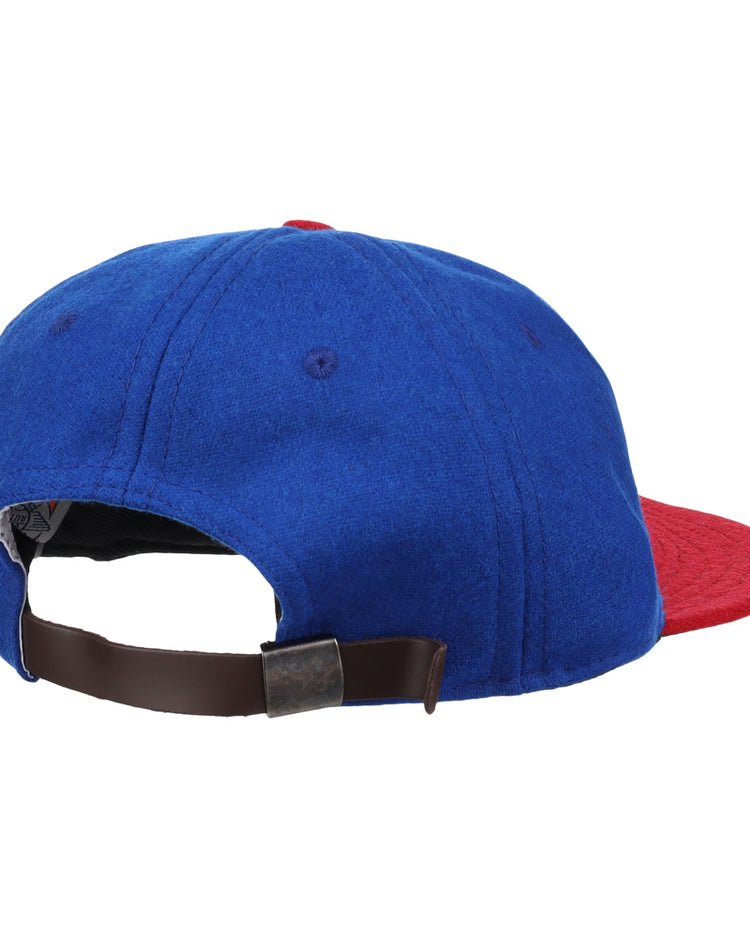 The Ebbets Field Flannels Miramar Yacht Club 1952 Vintage Ballcap is a genuine wool blue cap with a red brim, brown adjustable strap, and metal buckle—evoking the classic style of the original club ballcap.