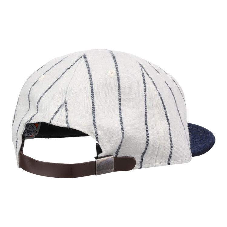 The Ebbets Field Flannels Vedado TC 1930 Vintage Ballcap features white fabric with thin navy stripes, a navy brim, and an adjustable brown strap with metal buckle, inspired by the Cuban National Amateur League classic.