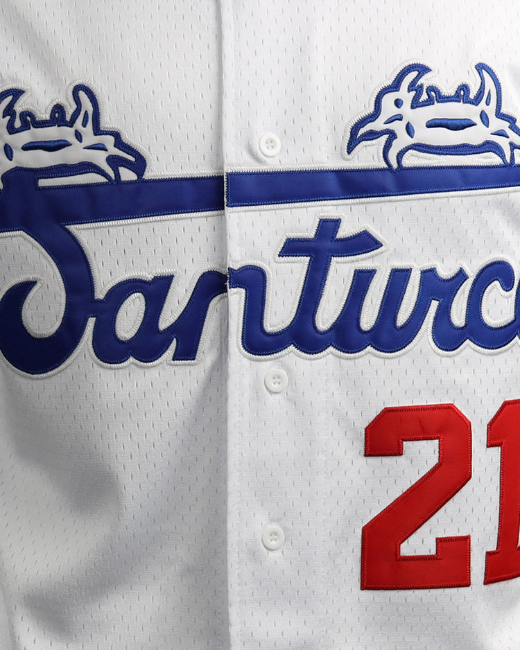 A close-up of the EFF Roberto Clemente Santurce Cangrejeros Vintage Inspired NL Replica Button-Up Mesh Jersey: white with blue Santurce script, blue crab graphics, and red 21 on the right side.