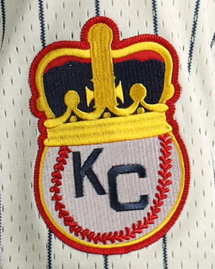 Embroidered patch featuring a gold crown atop a baseball with red stitching and KC letters, inspired by the Kansas City Monarchs, decorates this EFF Jackie Robinson Vintage Inspired NL Replica Button-Up Mesh Jersey.