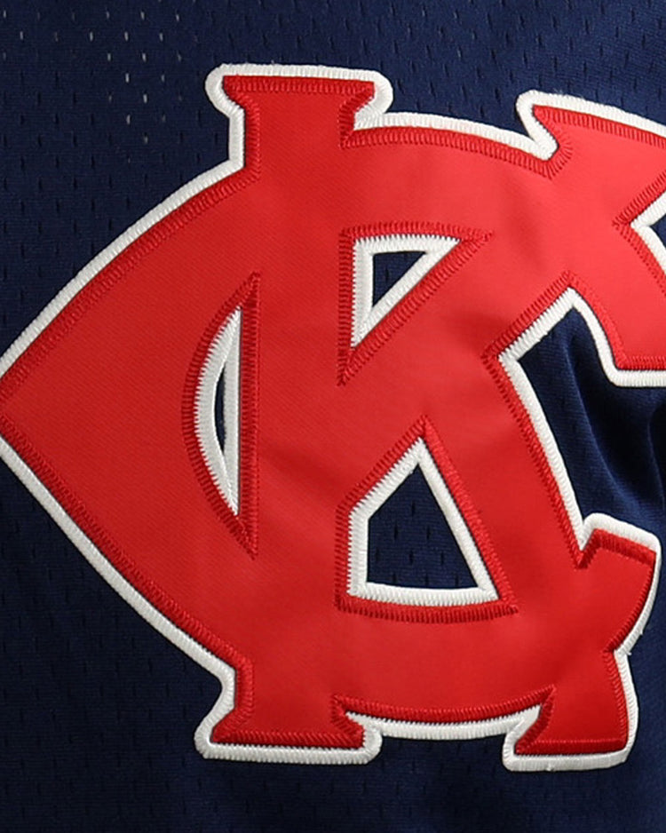 A close-up of the EFF Jackie Robinson Kansas City Monarchs Vintage Inspired NL Replica V-Neck Mesh Jersey, navy blue mesh with a bold red and white overlapping KC patch on the front.