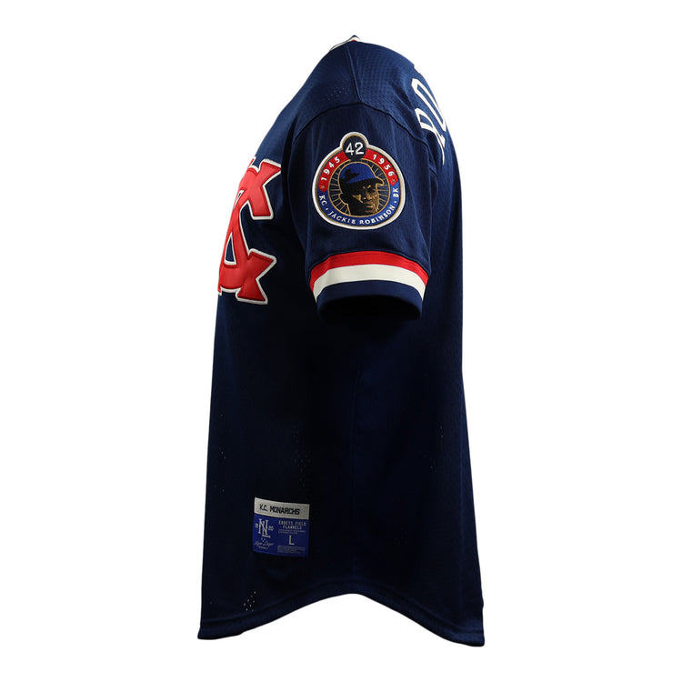 The EFF Jackie Robinson Kansas City Monarchs Vintage Inspired NL Replica V-Neck Mesh Jersey features navy mesh, red and white trim, a sleeve logo, number 42 patch, and a rectangular hem label—shown from the side.