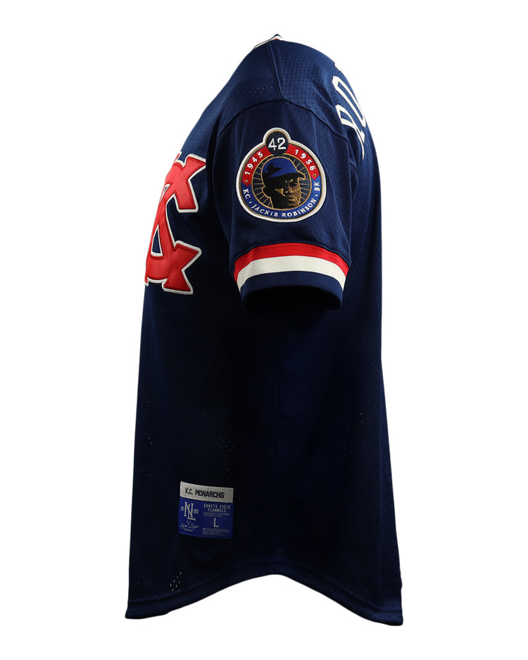 The EFF Jackie Robinson Kansas City Monarchs Vintage Inspired NL Replica V-Neck Mesh Jersey features navy mesh, red and white trim, a sleeve logo, number 42 patch, and a rectangular hem label—shown from the side.