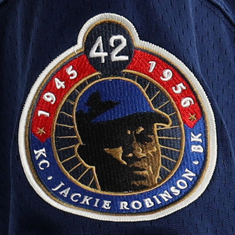 A navy blue commemorative patch with 42, 1945 & 1956, KC, BK, and Jackie Robinson’s portrait—ideal for EFF Jackie Robinson Kansas City Monarchs Vintage Inspired NL Replica V-Neck Mesh Jersey collectors.