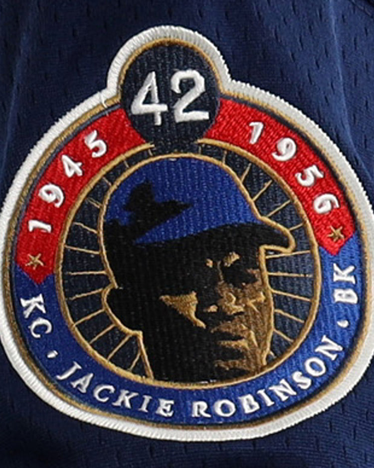 A navy blue commemorative patch with 42, 1945 & 1956, KC, BK, and Jackie Robinson’s portrait—ideal for EFF Jackie Robinson Kansas City Monarchs Vintage Inspired NL Replica V-Neck Mesh Jersey collectors.