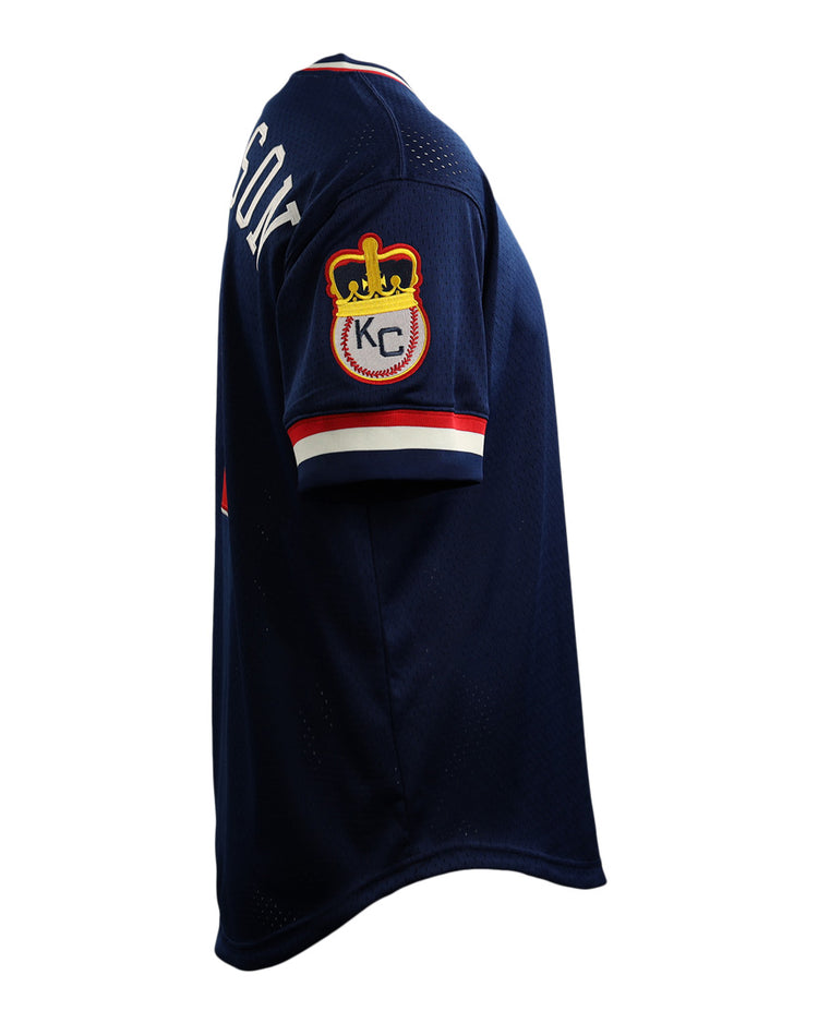 The EFF Jackie Robinson Kansas City Monarchs Vintage Inspired NL Replica V-Neck Mesh Jersey is navy blue with a crown and KC patch on the sleeve and partial white lettering on the back, inspired by classic mesh styles from Ebbets Field Flannels.
