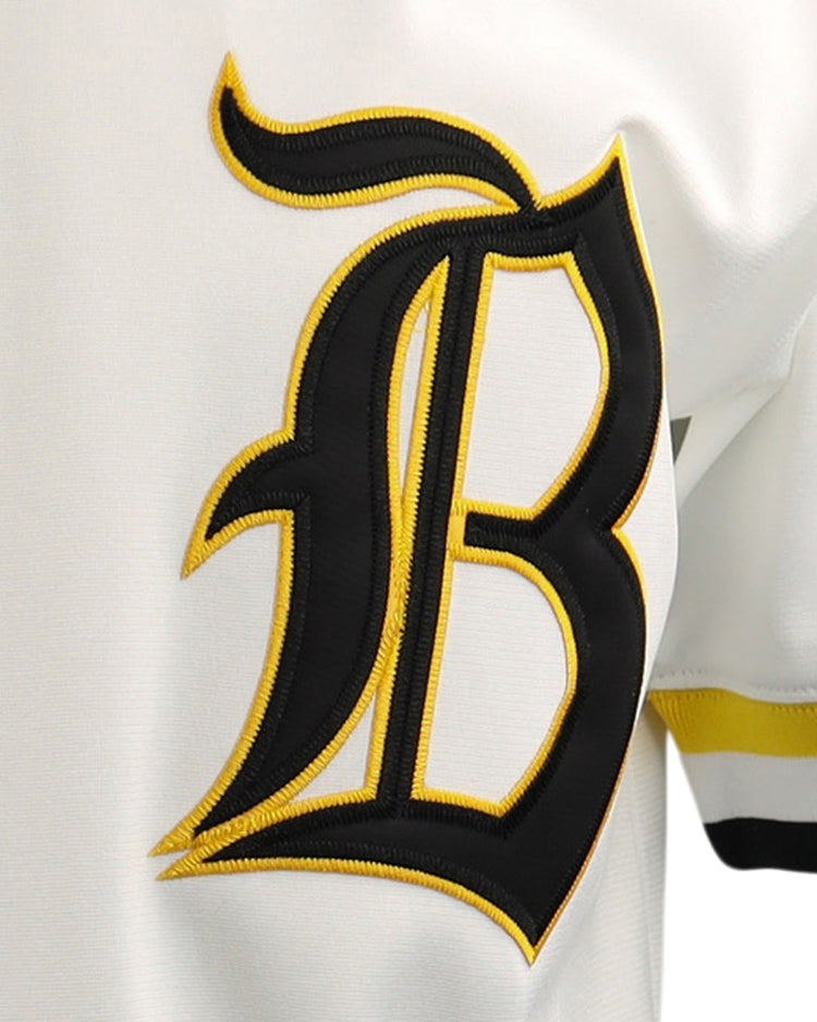 A close-up of the EFF Beeville Blazers EFF Lone Star Baseball Jersey, showcasing a bold black “B” outlined in yellow on the front and yellow-black sleeve stripes, worn during games at Joe Hunter Field.