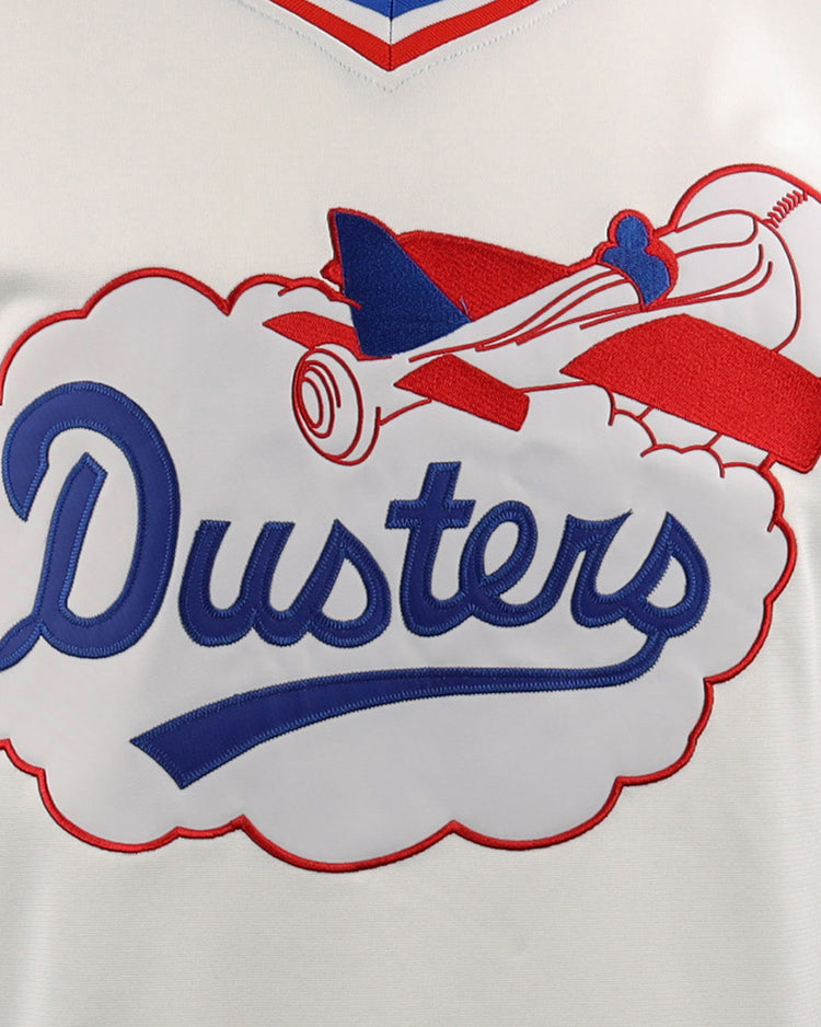 A close-up of the McAllen Dusters EFF Lone Star Baseball Jersey by EFF, showing a red and blue vintage airplane flying through a cloud with Dusters in blue script, outlined in red—design inspired by the local school district’s baseball field.