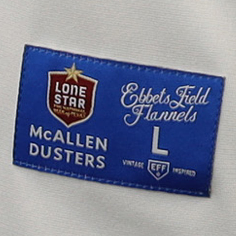 The McAllen Dusters EFF Lone Star Baseball Jersey by EFF features a blue and red label sewn onto white fabric—ideal for fans of classic baseball style.