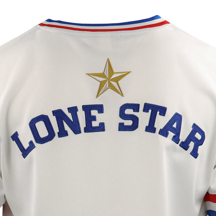 Close-up of the McAllen Dusters EFF Lone Star Baseball Jersey by EFF, featuring LONE STAR in blue letters with a gold star above and red and blue stripes on the collar, worn on a local school district baseball field.